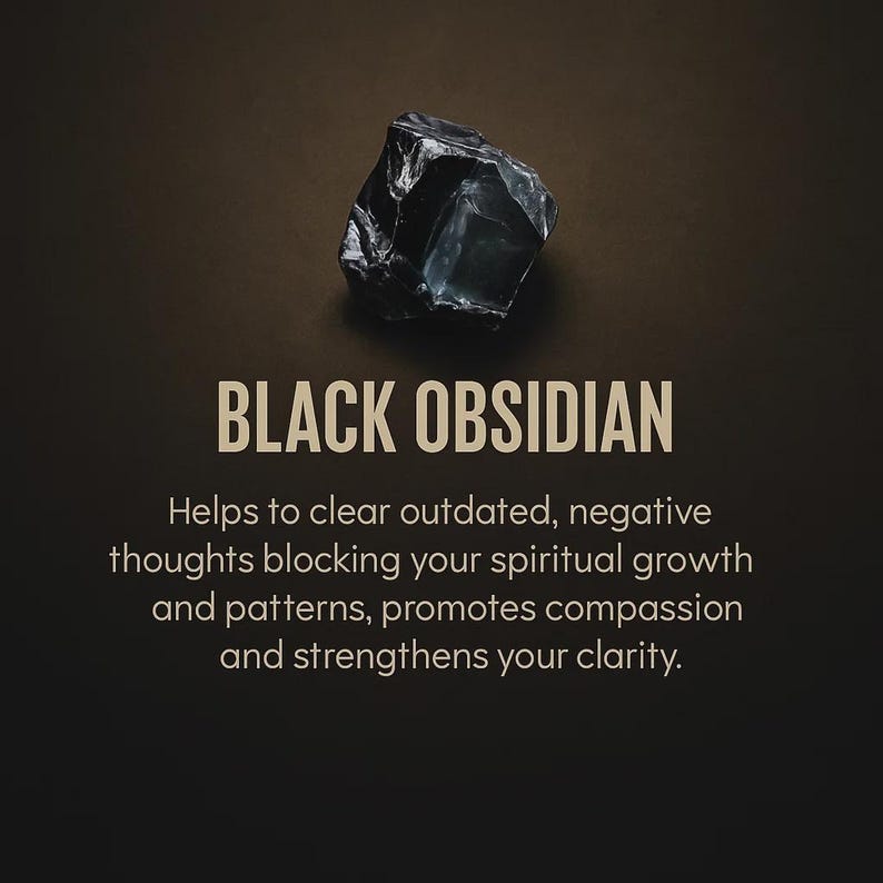 May include: A dark, glossy black obsidian stone against a brown background. The text "BLACK OBSIDIAN" is displayed below the stone, with additional text describing its properties. The stone is a natural, raw form.