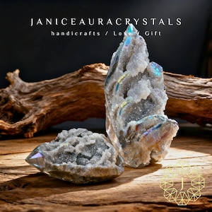 Puede incluir: Dos cristales de aura iridiscentes sobre una superficie de madera. Los cristales tienen una apariencia texturizada y cristalina con toques de azul, verde y morado. El texto "JANICEAURACRYSTALS handicrafts / Love Gift" está en la parte superior.