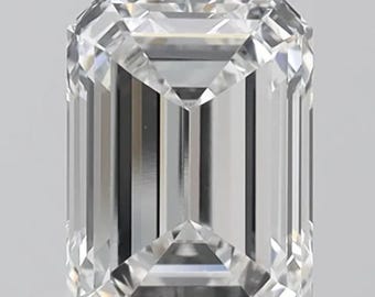 May include: A clear, emerald-cut diamond. The rectangular gemstone has faceted edges that reflect light, creating a brilliant sparkle. The diamond is set against a neutral background, highlighting its clarity and brilliance.