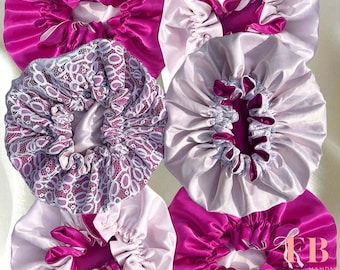 Può includere: Una collezione di cuffie in raso in vari colori, tra cui fucsia, lavanda e una cuffia con un rivestimento in pizzo. Le cuffie sono raccolte sulla corona e hanno un dettaglio in nastro di raso. Prodotto fatto a mano.