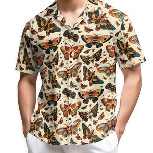 May include: A short-sleeved button-down shirt in a cream colour featuring an all-over print of various moths and butterflies in shades of orange, teal, black, and yellow. The shirt has a notched collar and a straight hemline with white buttons.