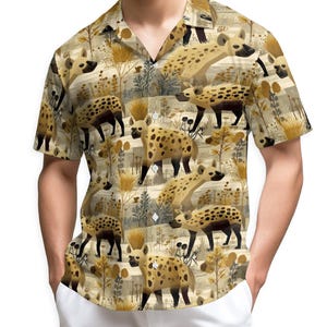 May include: Short-sleeved button-down shirt featuring a repeating pattern of hyenas in a naturalistic setting. The shirt's design incorporates a beige and brown color palette with detailed illustrations of the animals and foliage.