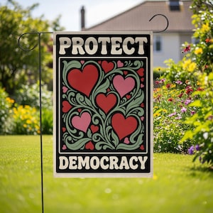 May include: A rectangular garden flag featuring a black background with the text PROTECT at the top and DEMOCRACY at the bottom in white. The center displays a decorative pattern of red and pink hearts intertwined with light green leafy vines.