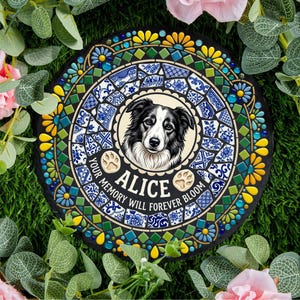 Puede incluir: Una losa redonda y negra con un borde de mosaico. El centro presenta un retrato de un perro blanco y negro llamado Alice, con huellas de patas y el texto "YOUR MEMORY WILL FOREVER BLOOM". El borde tiene azulejos azules, amarillos y verdes.