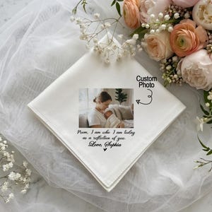 May include: White handkerchief with a custom photo and text. The photo shows a mother holding a baby. Text reads "Mom, I am who I am today as a reflection of you. Love, Sophia."