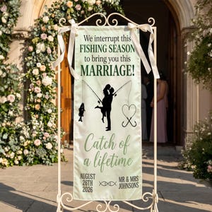 May include: A cream-colored wedding banner with the text "We interrupt this FISHING SEASON to bring you this MARRIAGE!" and "Catch of a lifetime." Features a silhouette of a couple kissing, fishing rods, and a heart-shaped hook. The date is August 26th, 2026.