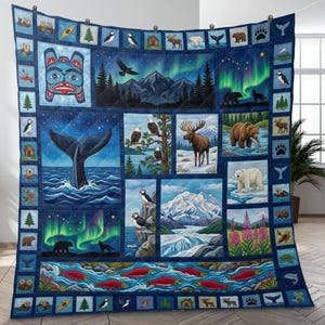 Puede incluir: Un edredón azul marino con varios animales salvajes y paisajes de Alaska. El edredón muestra imágenes de ballenas, osos, águilas y la aurora boreal. El diseño incluye una máscara nativa americana, montañas y peces rojos. El edredón está colgado en una pared.
