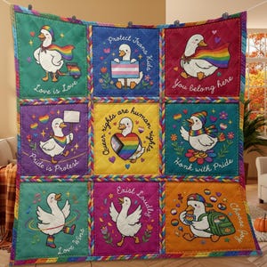 May include: A quilted throw blanket featuring nine square panels, each displaying a white goose with rainbow-themed accessories and text including 'Love is Love', 'Protect Trans Kids', 'You belong here', 'Pride is Protest', and 'Honk with Pride'.
