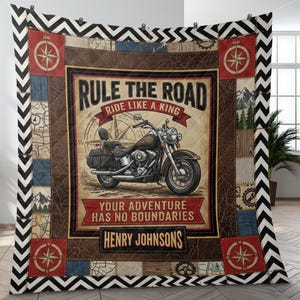 Könnte beinhalten: Eine Motorrad-Quiltdecke mit einem braunen, lederartigen Mittelteil mit einer Motorradillustration und dem Text "Rule the Road, Ride Like a King". Die Decke hat ein Kompassrosen-Design und den Namen "Henry Johnsons".