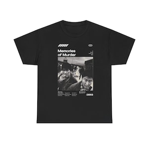 Può includere: T-shirt nera con un design di locandina del film "Memories of Murder". Il design include un'immagine in bianco e nero di due uomini, il titolo del film e l'anno 2003. La maglietta è realizzata in un materiale morbido.