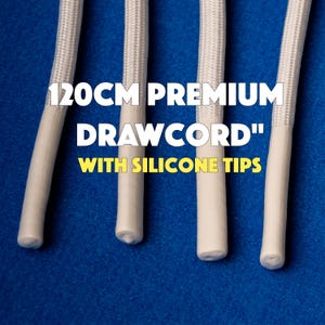 May include: Close-up of four white drawcords with silicone tips against a blue background. The text "120CM PREMIUM DRAWCORD" is displayed in white, with "WITH SILICONE TIPS" in yellow.