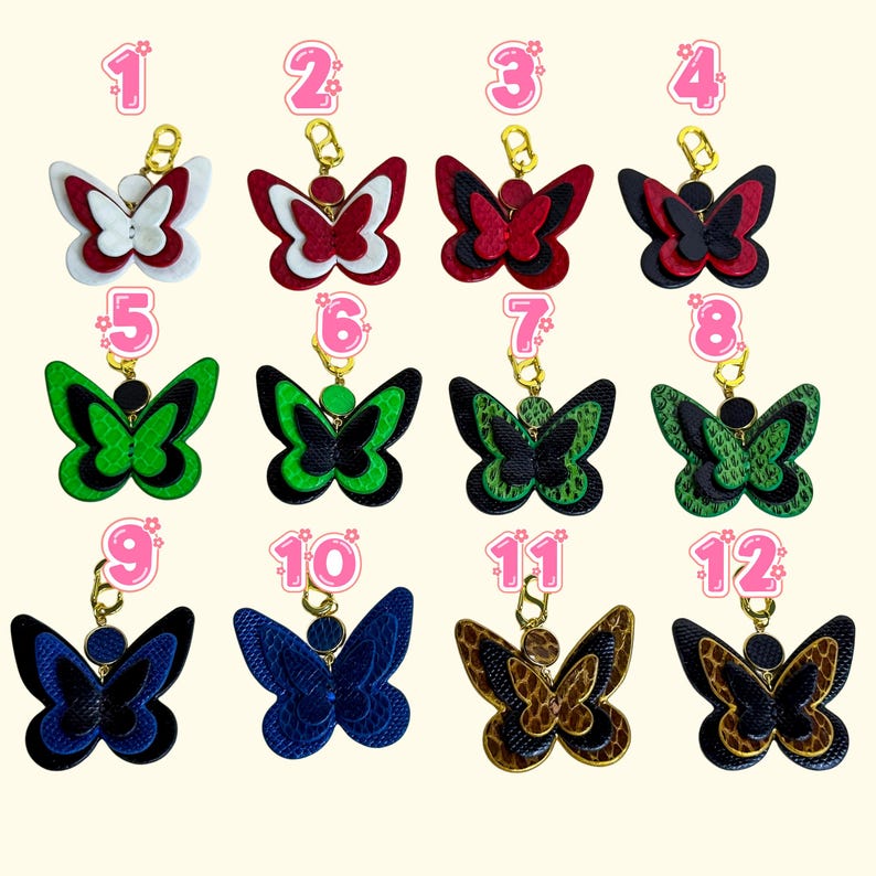Twelve handmade leather wallet charm options displayed in a numbered grid, each in a different butterfly color design. All styles are crafted from layered genuine snakeskin and French lambskin with gold-plated hardware. The image shows color choices including red, white, black, blue, green, and brown patterns. These leather purse charms and butterfly zipper charms help shoppers select the exact style they want.