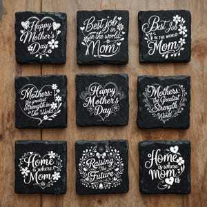 Peut inclure: Neuf dessous de verre carr&eacute;s en ardoise noire avec des textes et des motifs floraux grav&eacute;s en blanc. Les textes incluent des phrases comme Happy Mother's Day, Best job in the world Mom, Mothers the greatest strength in the world, Home is where mom is et Raising the future.