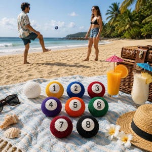 May include: A beach scene with a picnic blanket and a set of crocheted pool balls numbered 1-8. The balls are in various colors, including yellow, blue, red, purple, orange, and green. A white ball is also present. People are playing with a pool ball on the beach.