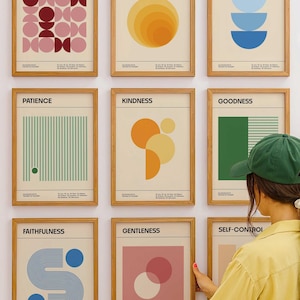 Könnte beinhalten: Neun gerahmte Kunstdrucke mit minimalistischen Designs und Wörtern wie "Liebe", "Freude" und "Frieden". Jeder Druck zeigt geometrische Formen und Pastellfarben, darunter Rosa, Blau und Gelb. Die Drucke werden an einer weißen Wand ausgestellt.