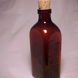 May include: A brown glass bottle with a cork stopper. The bottle is labeled "Wampole's Liquid Wheat".