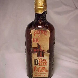 May include: A glass bottle with a gold cap and a label that reads "Pure Blood For Rain Raw Blood Romoc Company Sole Owners Providence R.I."