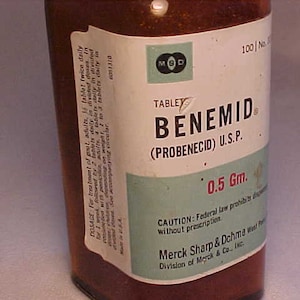 May include: A brown glass bottle with a white label that reads "BENEMID (PROBENECID) U.S.P. 0.5 Gm." The label also includes the text "CAUTION: Federal law prohibits dispensing without prescription" and "Merck Sharp & Dohme Division of Merck & Co., Inc."