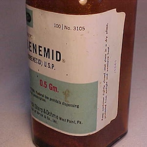 May include: A brown glass bottle with a white label that reads "100 | No. 3105" and "ENEMID (BENECID) U.S.P." The label also includes the text "0.5 Gm." and "Federal law prohibits dispensing" and "Sharp & Dohme West Point, Pa."
