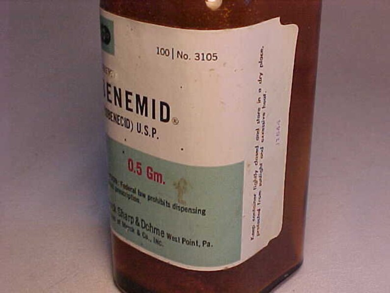 May include: A brown glass bottle with a white label that reads "100 | No. 3105" and "ENEMID (BENECID) U.S.P." The label also includes the text "0.5 Gm." and "Federal law prohibits dispensing" and "Sharp & Dohme West Point, Pa."