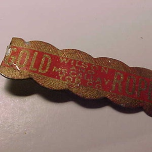 May include: A gold and red metal pin with the words "Gold Rope" and "Wilson & McLay, Toronto" on it.
