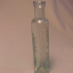 May include: A clear glass bottle with a green label that reads "Dr. Knapp's  Petroleum  Oil  -  REILLY &  BRENNAN  -  CHICAGO"