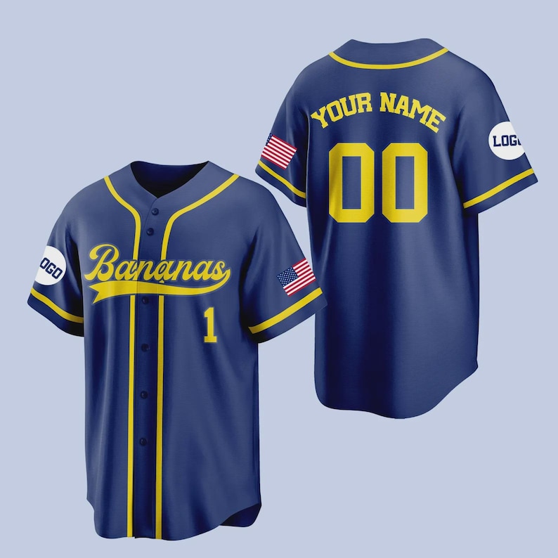 Op de afbeelding: Marineblauw honkbalshirt met gele accenten. Het shirt toont het woord "Bananas" in gele letters, het nummer "1" eronder, en de tekst "YOUR NAME" en het nummer "00" op de rug. Amerikaanse vlagpatches staan op de mouwen.