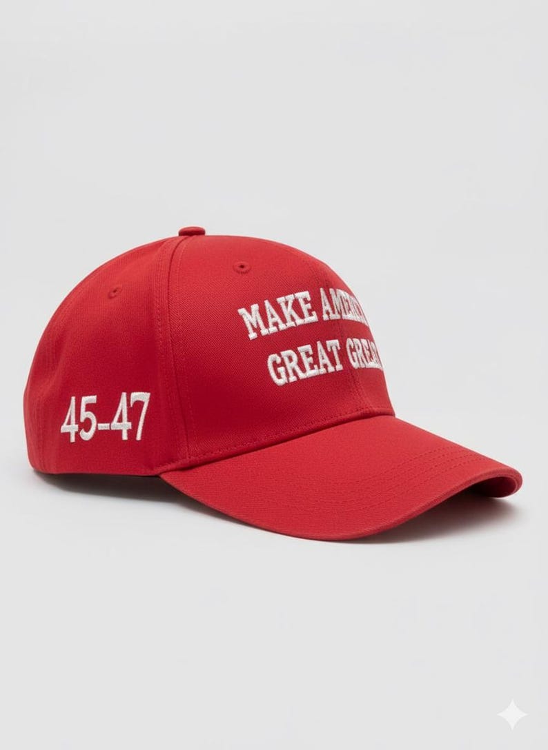 May include: A red baseball cap with the text "MAKE AMERICA GREAT AGAIN" in white block letters. The number "45-47" is printed on the side of the cap in white. The cap has a curved brim and a button on top.