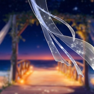 Puede incluir: Una romántica escena de boda en la playa al anochecer. Un velo blanco y fluido con acentos brillantes flota en primer plano. Un arco de madera cubierto con tela blanca y vegetación conduce a una pasarela de madera sobre la arena, con el océano al fondo.