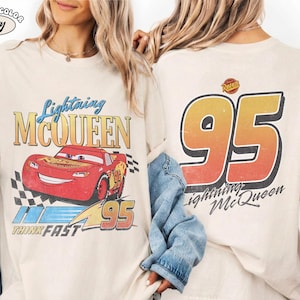 Puede incluir: Camiseta de color marfil con Lightning McQueen de la pel&iacute;cula Cars. El gr&aacute;fico frontal muestra el coche de carreras rojo con el texto "Lightning McQueen", "Think Fast" y el n&uacute;mero "95". La parte trasera muestra un gran "95" y "Lightning McQueen".