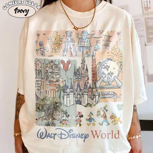 Peut inclure: T-shirt ivoire Comfort Color avec une illustration color&eacute;e des monuments et personnages de Walt Disney World. Le design comprend le ch&acirc;teau de Cendrillon, Spaceship Earth et Mickey et Minnie Mouse. Les mots "Walt Disney World" sont imprim&eacute;s en bas.