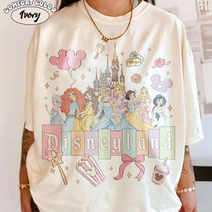 May include: A white ceramic mug with a black handle and the text "But First, Coffee" in a black, handwritten-style font. The mug is on a white surface.