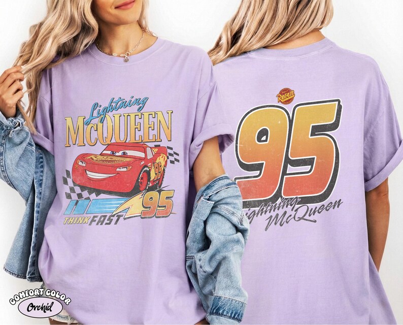 Puede incluir: Camiseta de color lila con un dise&ntilde;o de Rayo McQueen de la pel&iacute;cula Cars. El frente muestra a McQueen, el texto "Lightning McQueen" y "95". La parte trasera presenta un gran "95" y el texto "Lightning McQueen".