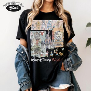Peut inclure: T-shirt noir Comfort Colors avec un graphisme color&eacute; des monuments et personnages de Walt Disney World. Le design comprend le ch&acirc;teau de Cendrillon, Mickey Mouse et d'autres &eacute;l&eacute;ments embl&eacute;matiques. Le texte "Walt Disney World" est imprim&eacute; en dessous.