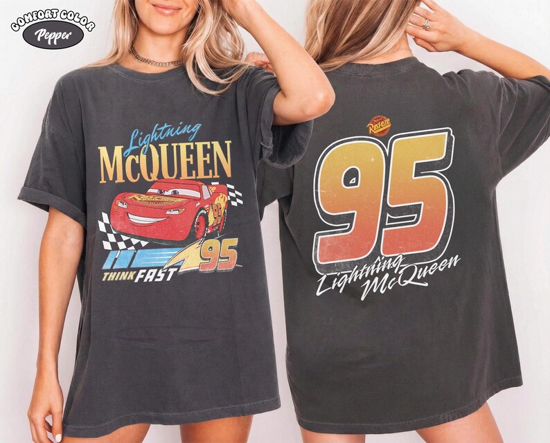 Puede incluir: Camiseta gris oscuro con Lightning McQueen de la pel&iacute;cula Cars. El gr&aacute;fico frontal muestra a McQueen con el n&uacute;mero 95 y "Think Fast". La parte trasera muestra un gran "95" y "Lightning McQueen".
