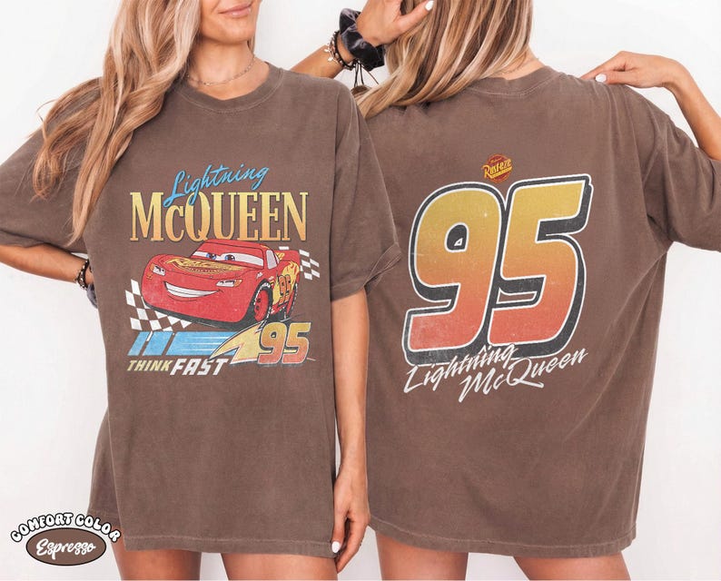 Puede incluir: Camiseta marr&oacute;n con Lightning McQueen de la pel&iacute;cula Cars. La parte delantera muestra un dise&ntilde;o de coche de carreras rojo con el texto "Lightning McQueen" y "95". La parte trasera muestra un gran "95" con "Lightning McQueen" debajo.