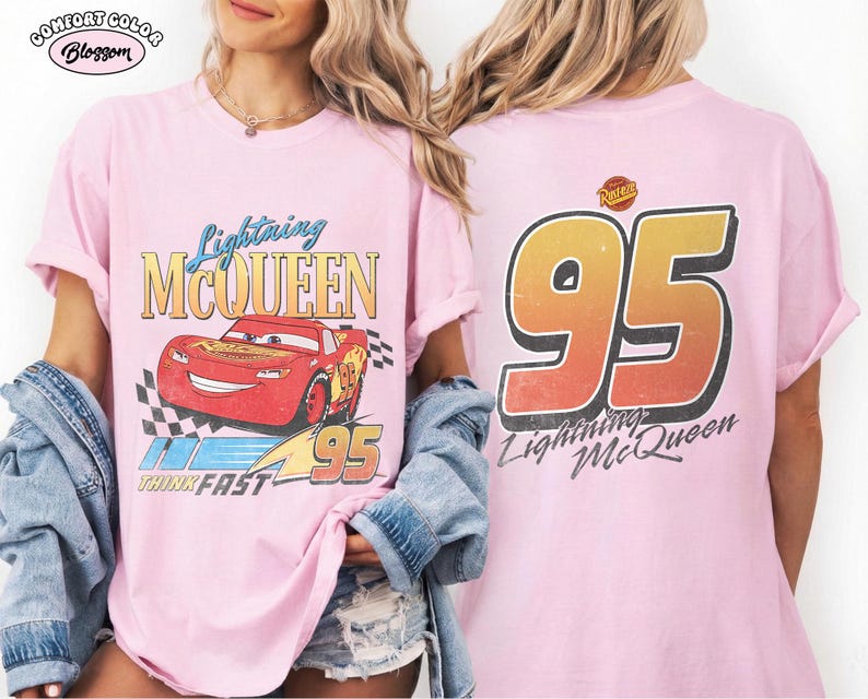 Puede incluir: Camiseta rosa claro con Lightning McQueen de la pel&iacute;cula Cars. El frente muestra el personaje, texto y una bandera a cuadros. La parte posterior muestra un gran "95" y las palabras "Lightning McQueen".