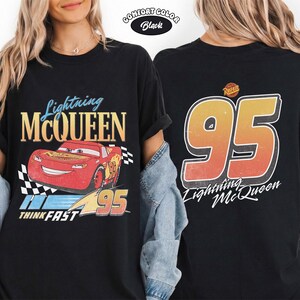 Puede incluir: Camiseta negra Comfort Color con Lightning McQueen de la pel&iacute;cula Cars. El gr&aacute;fico frontal incluye a McQueen, el n&uacute;mero 95 y la frase "Think Fast". La parte trasera muestra un gran n&uacute;mero 95 y "Lightning McQueen".