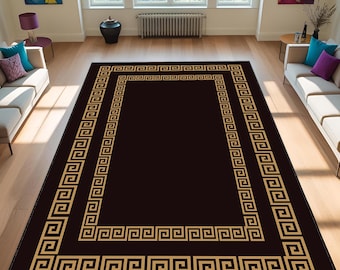 May include: A rectangular area rug with a dark brown center and a gold Greek key border. The rug is placed on a light-colored hardwood floor in a living room setting. The rug's design adds a touch of classic elegance to the room.