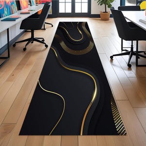 Puede incluir: Una alfombra larga y rectangular negra con diseños abstractos dorados. La alfombra presenta un efecto de capas con un borde dorado punteado en un extremo. El diseño es moderno y elegante, adecuado para un pasillo o entrada.