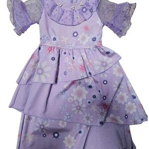 Puede incluir: Un vestido lavanda con un estampado floral, con una falda escalonada y mangas con volantes. El corpiño tiene un cuello decorativo con detalles de perlas. El vestido está diseñado con cierre de cremallera y es adecuado para ocasiones especiales.