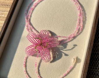 Collar largo con cuentas de lirio rosa: joyería artesanal con perlas colgantes.