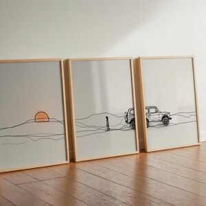 Puede incluir: Tres impresiones artísticas enmarcadas con dibujos lineales minimalistas. La primera representa una puesta de sol sobre una cordillera, la segunda una persona caminando y la tercera un vehículo. Los marcos son de madera clara, sobre un fondo neutro.