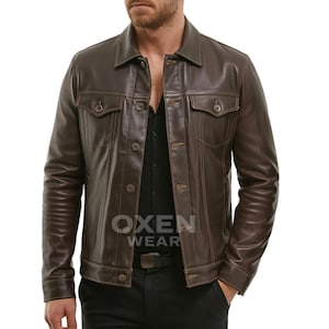 Könnte beinhalten: Braune Lederjacke mit Knopfverschlüssen, zwei Brusttaschen und einem Kragen. Die Jacke hat ein klassisches Design und besteht aus glattem, glänzendem Leder. Die Jacke ist mittelbraun und hat eine taillierte Passform.