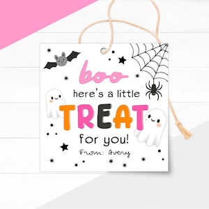May include: A square white Halloween gift tag with a string. The tag features a bat, spiderweb, and ghosts. Text includes "boo", "here's a little TREAT for you!" in pink, orange, and black. From: Avery.