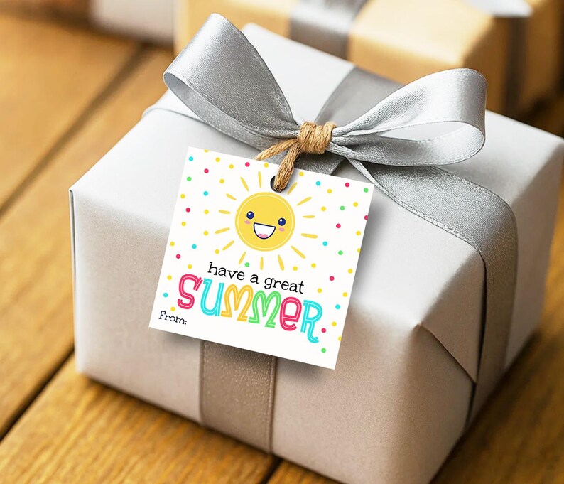 K&ouml;nnte beinhalten: Ein quadratisches wei&szlig;es Geschenkanh&auml;nger-Schild mit einer gelben, l&auml;chelnden Sonnenillustration, bunten Punkten und dem Text "have a great SUMMER" in mehrfarbigen Buchstaben sowie einer "From:"-Zeile unten, befestigt an einem silber verpackten Geschenk.