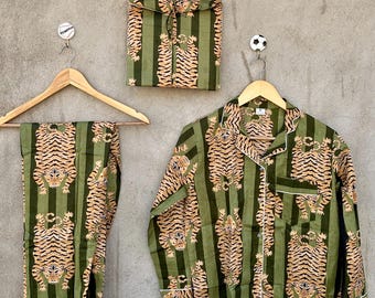 May include: A pajama set consisting of a long-sleeved button-down shirt and matching pants, accompanied by a folded fabric pouch. The garments feature a repeating tiger pattern over a dark and light green vertical striped background.