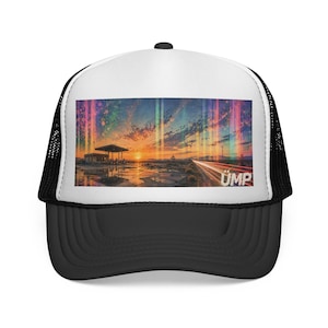 May include: A black and white trucker hat featuring a rectangular graphic print of a desert gas station at sunset with light streaks and the text UMP in the bottom right corner. The hat has a white front panel, black mesh back, and black brim.