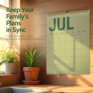 May include: A wall calendar for July with green text and a spiral binding. The calendar is hanging on a wooden wall. Text on the calendar reads "Keep Your Family's Plans in Sync. Track birthdays, trips, and special moments together."