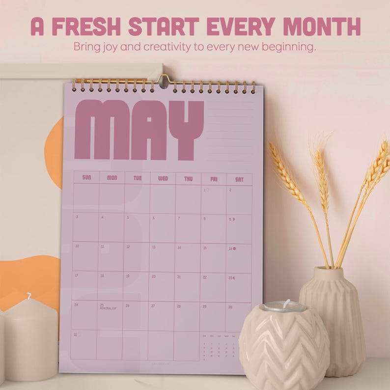 May include: A spiral-bound calendar for May, featuring a light purple background and bold, retro-style lettering. The calendar includes the text "A FRESH START EVERY MONTH" and "Bring joy and creativity to every new beginning."